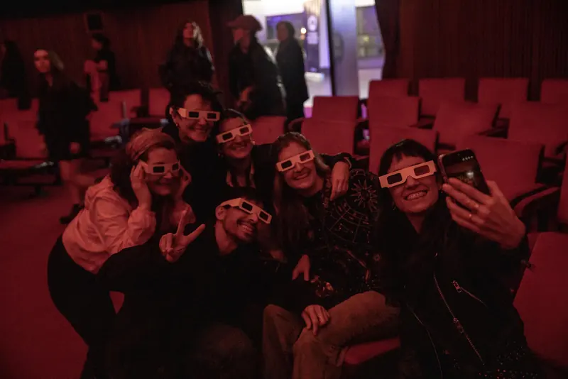 Un grupo de espectadores con lentes 3D se saca una selfie en las butacas del planetario